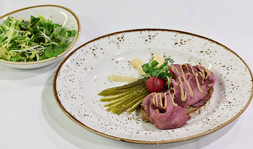 ZÜNFTIGE VORSPEIS` BRAUMEISTER HOLZOFENBROT Pastrami, Schmankerlgurken, Radieschen, marinierter Rettich, Barbeque Sauce, dazu Romanasalat